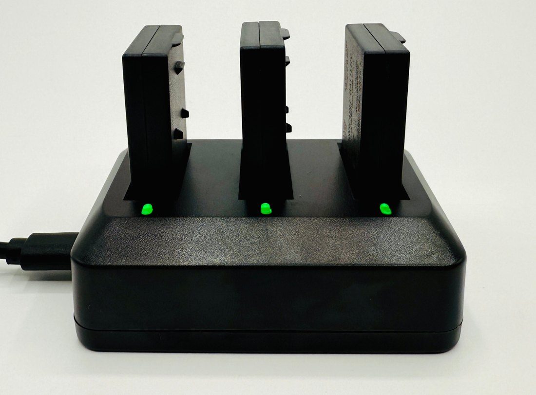 Charging dock with three batteries, indicator lights green