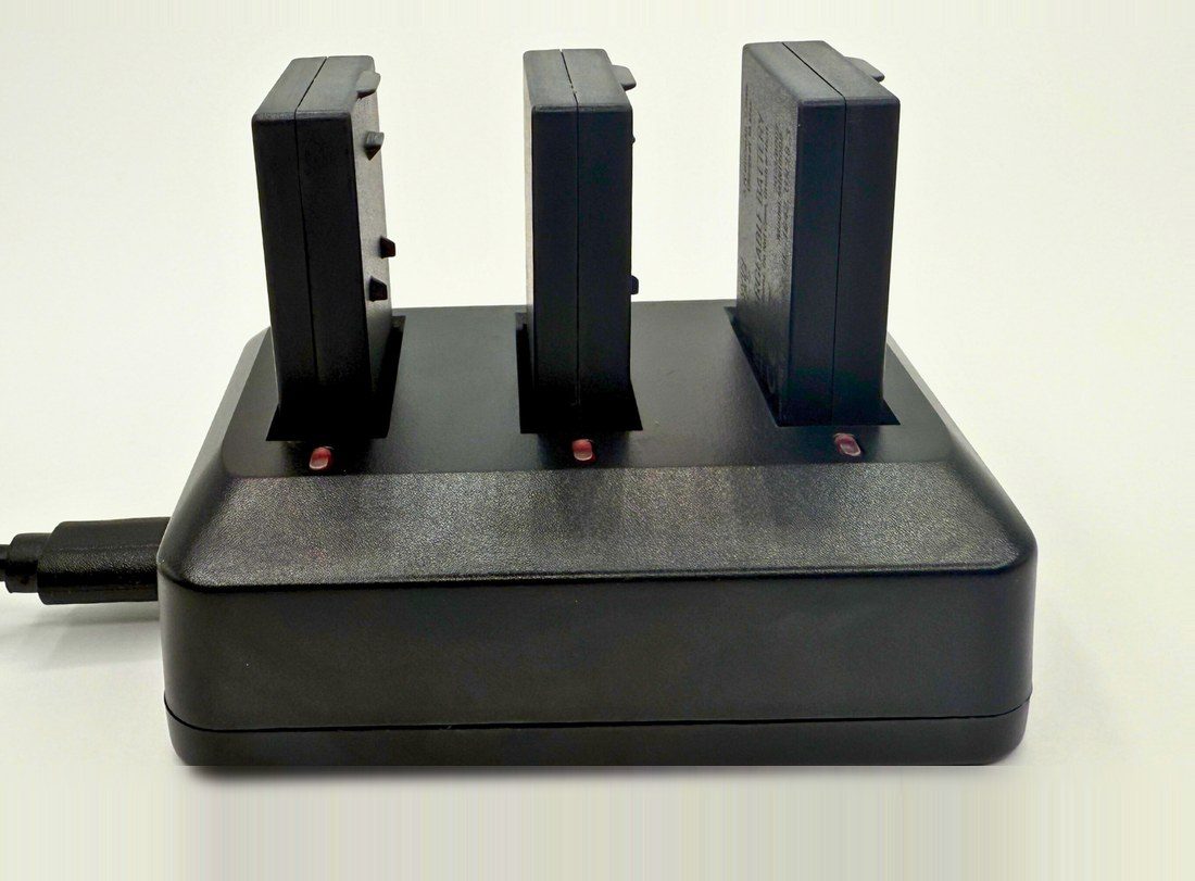 Charging dock with three batteries, indicator lights red